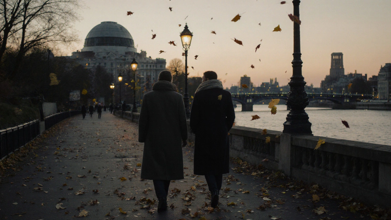 Two people walking calmly along the Greenwich riverside at sunset, embodying companionship in a peaceful setting.