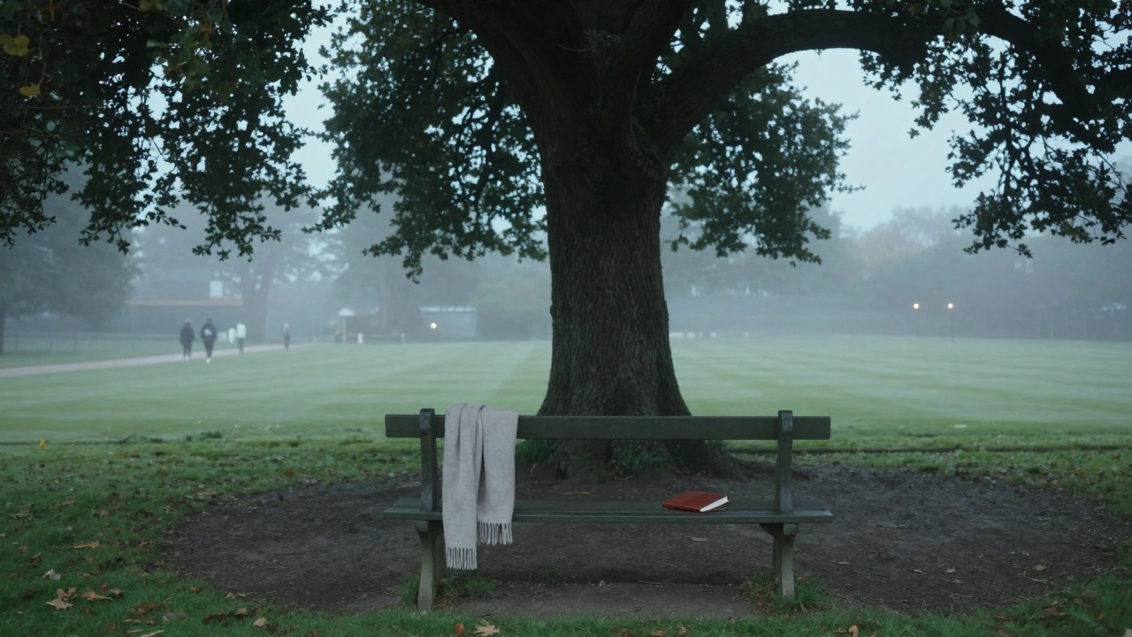 An empty bench on Wimbledon Common at dawn, with a scarf and notebook left behind.