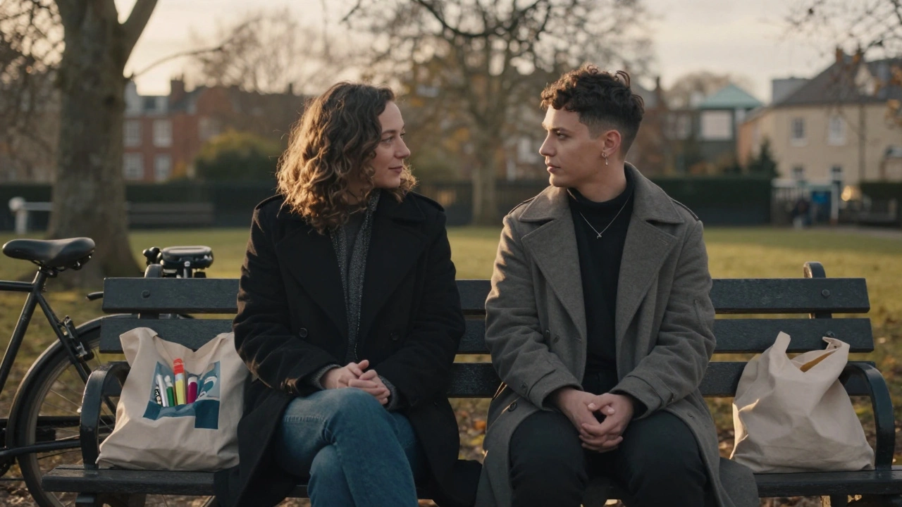 Two people sitting together on a park bench in Stoke Newington, sharing a coat and talking quietly at sunset.